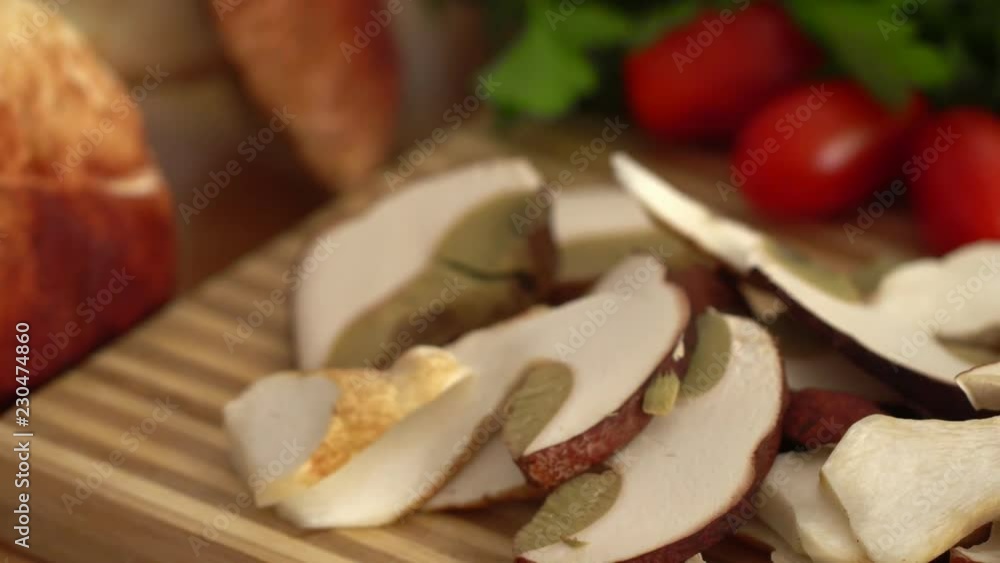 On a chopping board the cut mushrooms lie. Nearby tomatoes, garlic, green salad. On a chopping board the cut mushrooms lie. Nearby tomatoes, garlic, green salad.