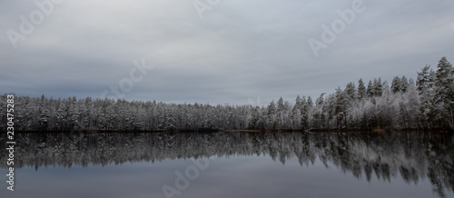 Autumn lake scenery with first snow flakes