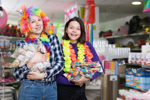 Smiling female friends with bags of confetti
