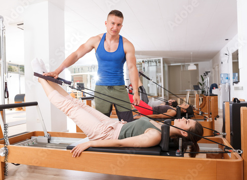 people in the gym doing exercises with modern fitness equipment