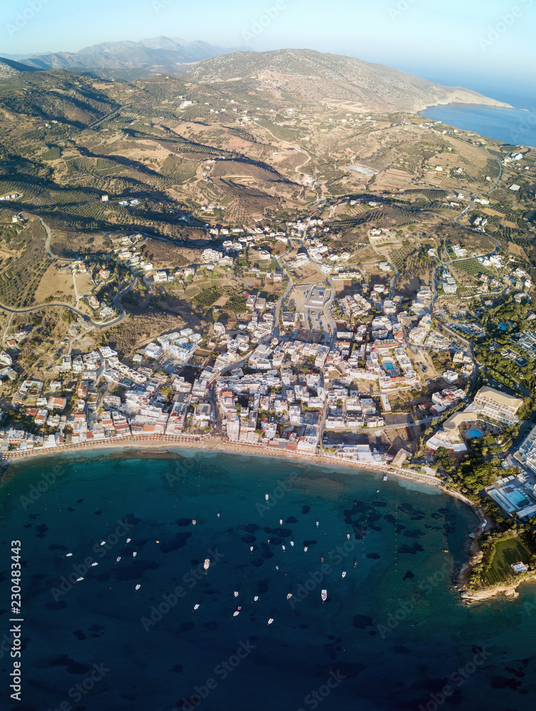 Aerial drone photo of beautiful bay with sandy beach and cretan village of Agia Pelagia, Greece