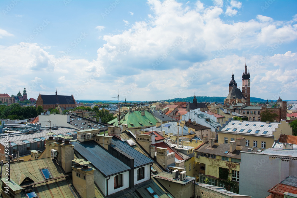 A view over the roof tops of old town Krakow in Poland. St. Mary's Basilica can be seen in the background right and Wawel Cathedral in the background far left
