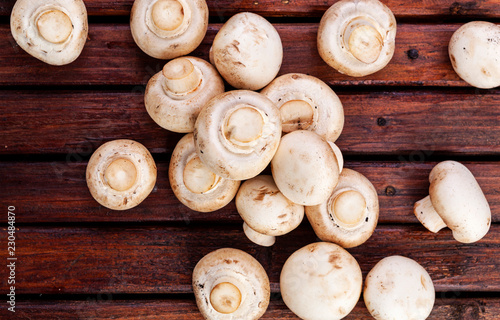Fresh champignon mushrooms on wooden table, top view. Copy space