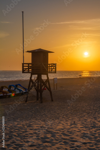 The sun setting behind a lifeguard tower in Rota, Spain.