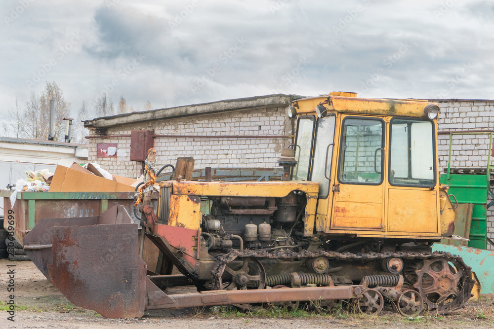 old rusty yellow abandoned tractor with bucket