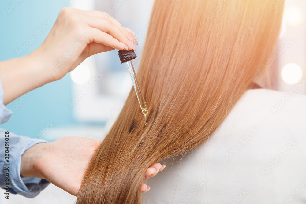 Close-up drop of oil restore and recovery hair is applied to head bulbs. hairdresser spa salon. Close-up drop of oil restore and recovery hair is applied to head bulbs. hairdresser spa salon.
