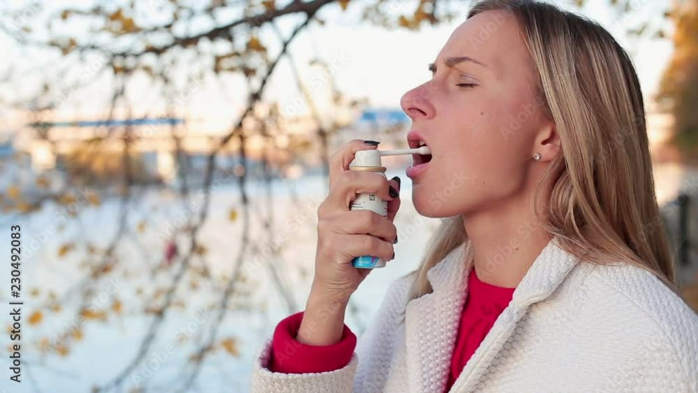 Woman using throat spray. Health and medical concept Woman using throat spray. Health and medical concept