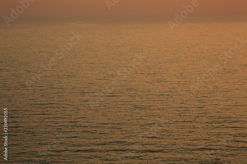 Sunset golden light reflection on sea wave ripple surface background. Abstract  tranquility  travel  serenity  romance  refresh  loneliness  relaxation  rest  cheering up  beauty in nature concept.