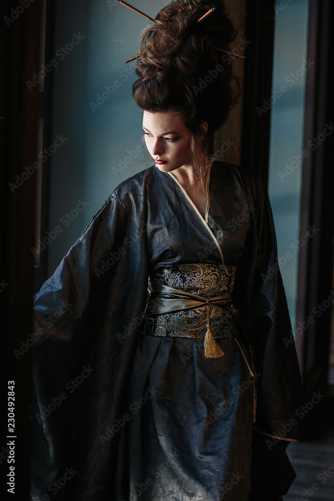 Sensual young woman in a geisha asian costume with fashion makeup and hair style