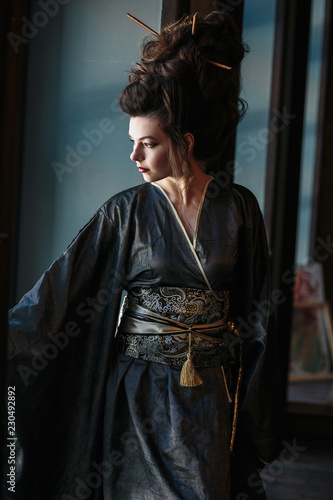 Sensual young woman in a geisha asian costume with fashion makeup and hair style