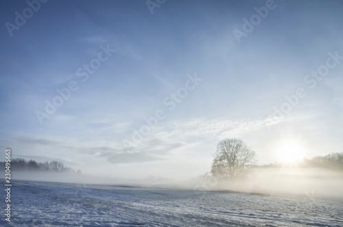 Sunrise and mist over winter nature scenery