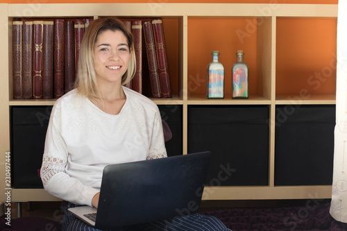 Girl searches online content on a laptop at home photo