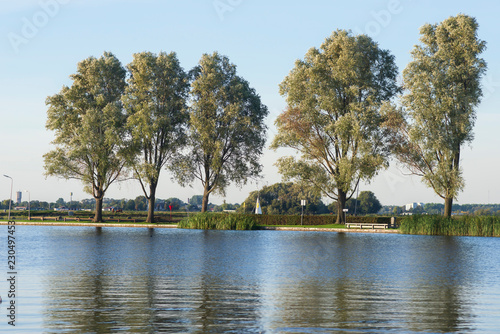 Sunny weekend, trees and sailing boats on the lake near Leiden, Netherlands photo