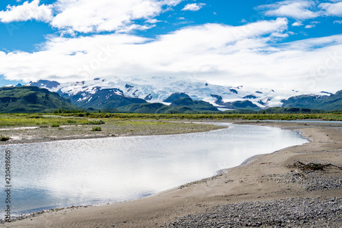 Katmai National Park with river, beach, sand and mountains with glaciers. Sunny summer day in Alaska