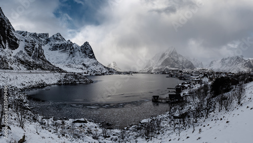 Amazing view to the winter Reine village with dramatic sky. Northern Norway, Lofoten Islands. Panorama