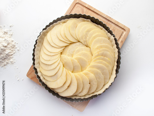 Tarta de manzana cruda dentro de un molde rizado visto cenitalmente