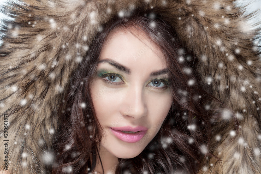 Portrait of a beautiful woman with beautiful make-up in a fur coat on a background of snow. Portrait of a beautiful woman with beautiful make-up in a fur coat on a background of snow.