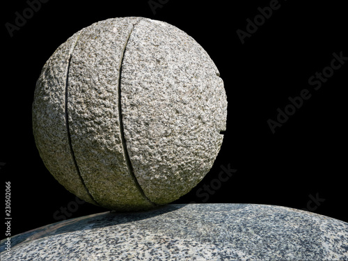 Stone ball on rock pedestal photo