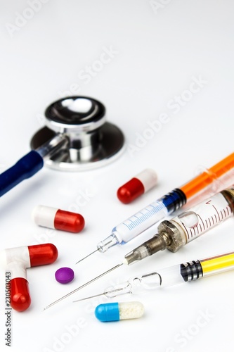 Assorted medical drugs and syringe on white background. Injection for the patient. Syringe, medical injection. Flu Treatment. Pharmaceutical industry.