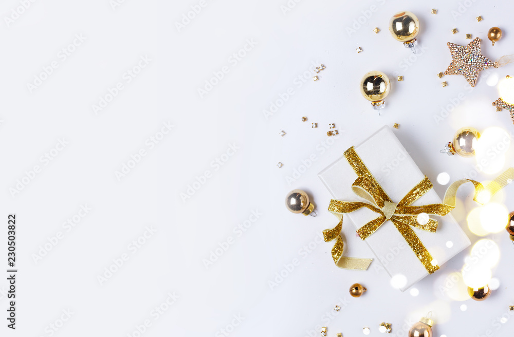 Fototapeta premium Świąteczna płaska scena świecka z pudełkiem git ze złotym węzłem łukowym i złotymi dekoracjami