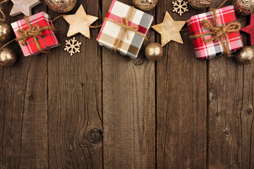 Christmas top border with gifts and rustic decorations on an aged wood background