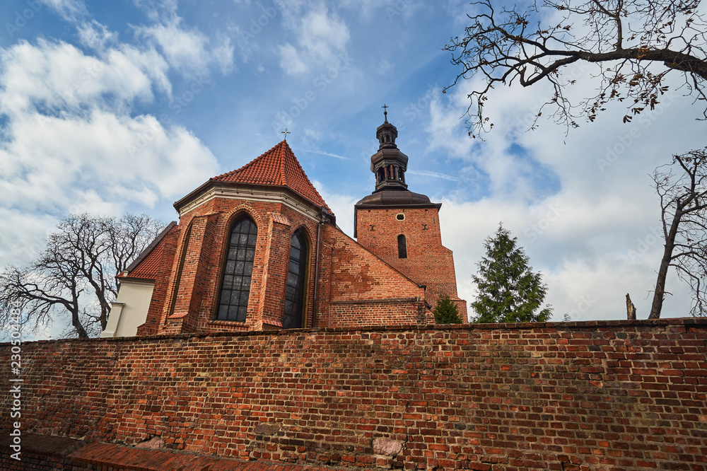 Brick, medieval wall and the Gothic parish church in Gniezno.