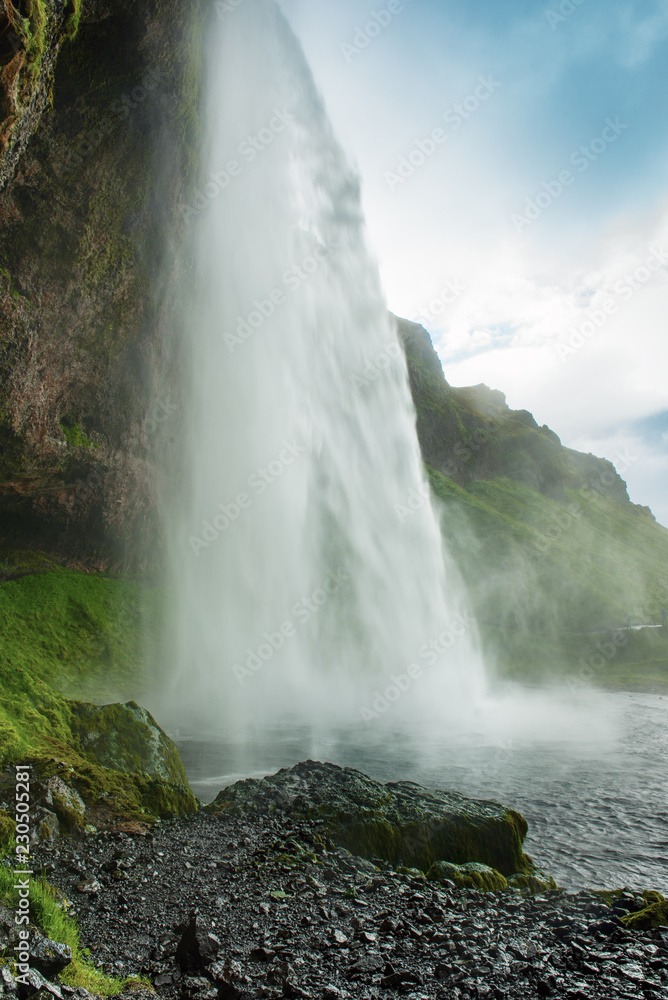 Famous waterfall Seljalandsfoss in Iceland, adventure outdoor travel Icelandic summer background Famous waterfall Seljalandsfoss in Iceland, adventure outdoor travel Icelandic summer background
