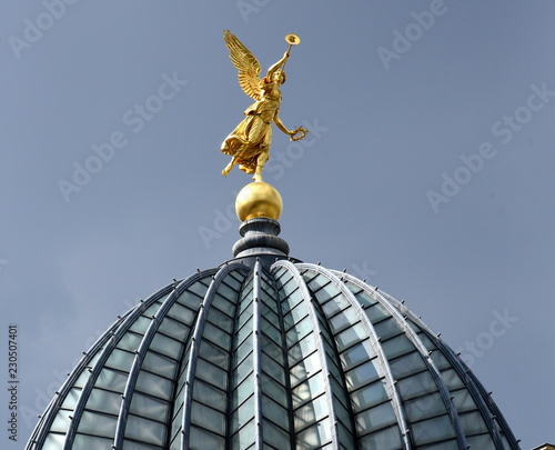 Goldene Fama-Figur auf der gefalteten Glaskuppe ("Zitronenpresse") der Kunstakademie vor blauem Himmel