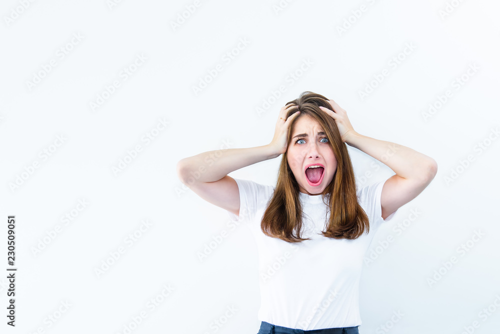 Horrible, stress, shock. Young emotional suprised woman looks at camera, clasping head in hands and opening her mouth isolated on white background. Human emotion, facial expression concept. Copy space Horrible, stress, shock. Young emotional suprised woman looks at camera, clasping head in hands and opening her mouth isolated on white background. Human emotion, facial expression concept. Copy space