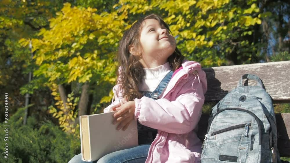 The child is reading a book. Girl with a book in the park. The child is reading a book. Girl with a book in the park.