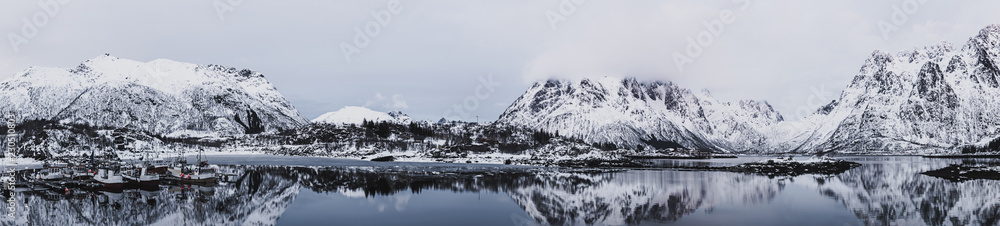 Fototapeta premium Landscape with beautiful winter lake and snowy mountains at Lofoten Islands in Northern Norway. Panoramic view
