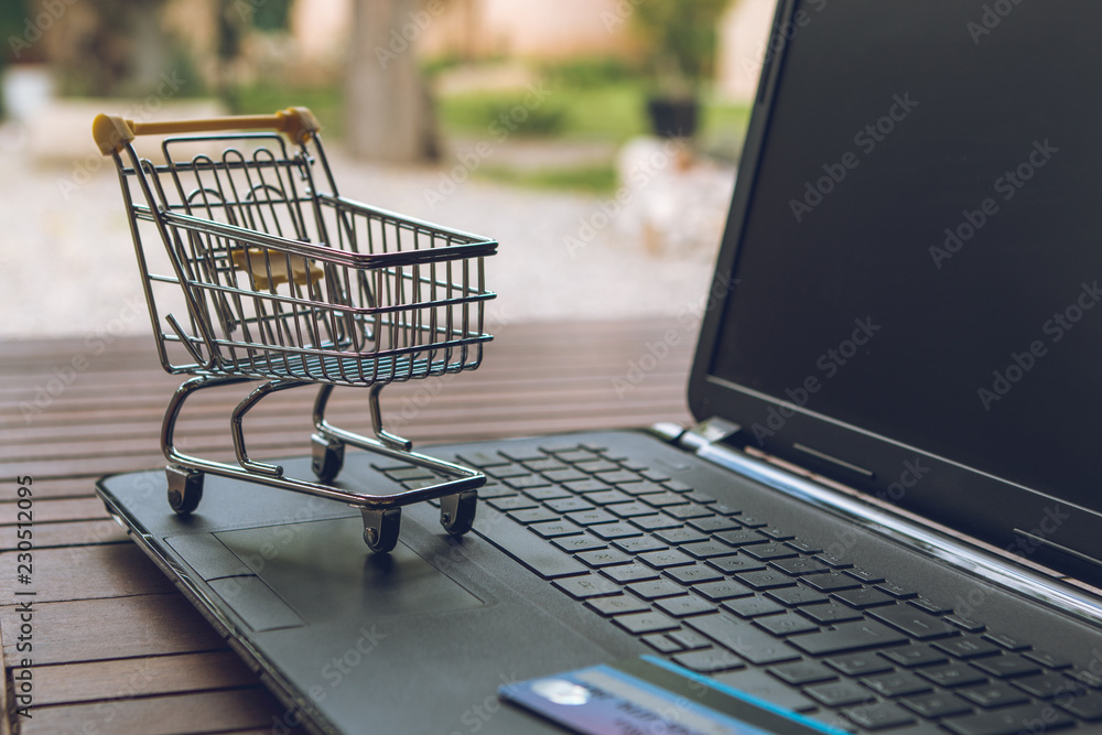 Small trolley on a computer keyboard. Shopping sales concept.