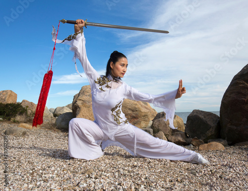 Foto Young woman dancer with a sword on a Connecticut beach.