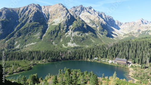 Poprad pleso and Tatra peaks visible from the back. A popular place from which many tourists embark on high mountains. Beautiful nature, blue sky and unparalleled peaks.