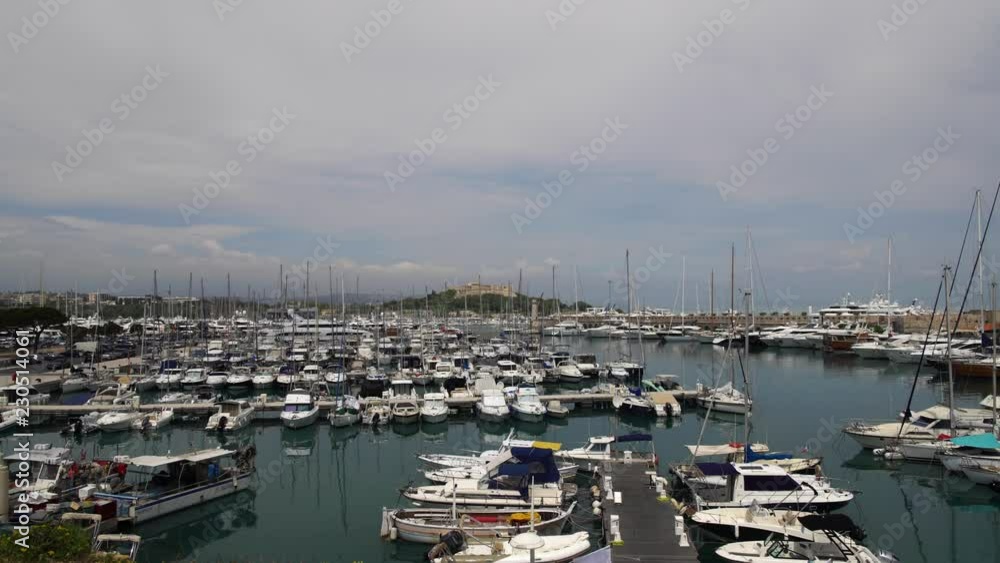 Yachts standing in harbour of French luxury resort Antibes on cloudy spring day. Concept of travel and luxury lifestyle. Locked down real time establishing shot Yachts standing in harbour of French luxury resort Antibes on cloudy spring day. Concept of travel and luxury lifestyle. Locked down real time establishing shot