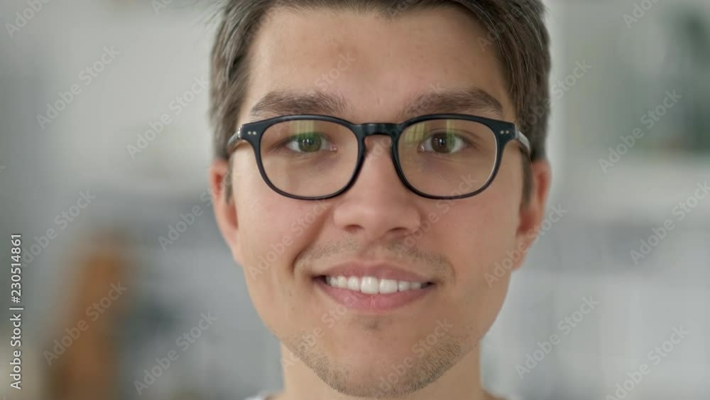 close up portrait of young asian teenager man looking serious confident at camera in apartment windows background slow motion. close up portrait of young asian teenager man looking serious confident at camera in apartment windows background slow motion.