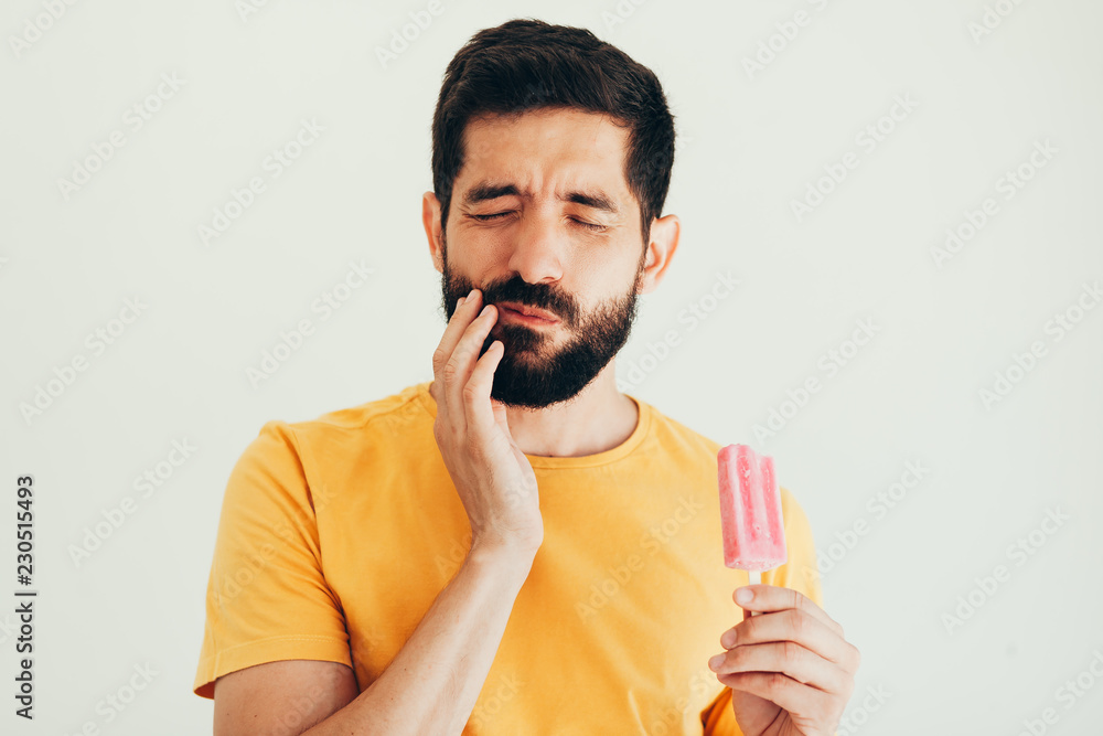Man have sensitive teeth with ice on white background Man have sensitive teeth with ice on white background