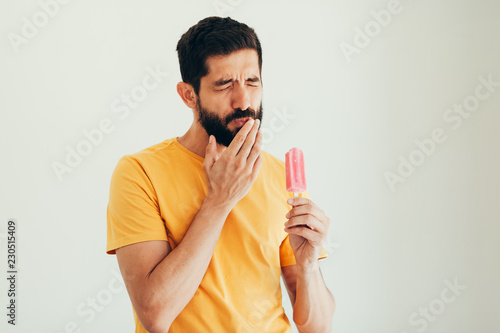 Schilderij op canvas Man have sensitive teeth with ice on white background