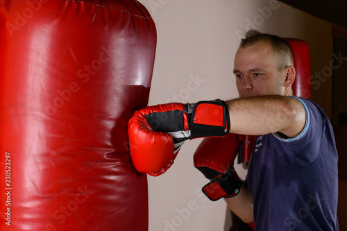male boxer practicing punches on a punching bag in the gym © smspsy