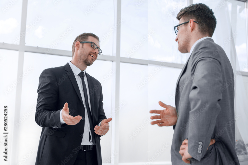 bottom view.business colleagues talking while standing in office bottom view.business colleagues talking while standing in office