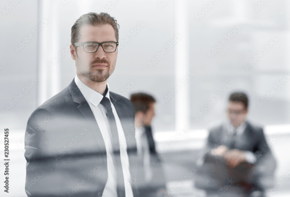 confident businessman looking through the office window confident businessman looking through the office window