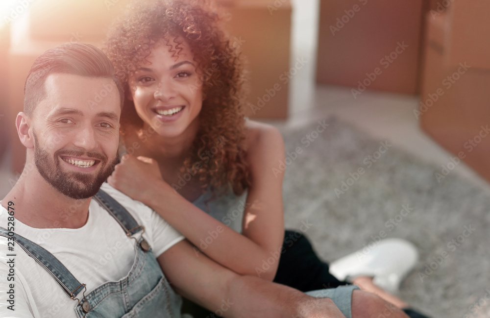 Young couple sitting on the floor in a new apartment Young couple sitting on the floor in a new apartment