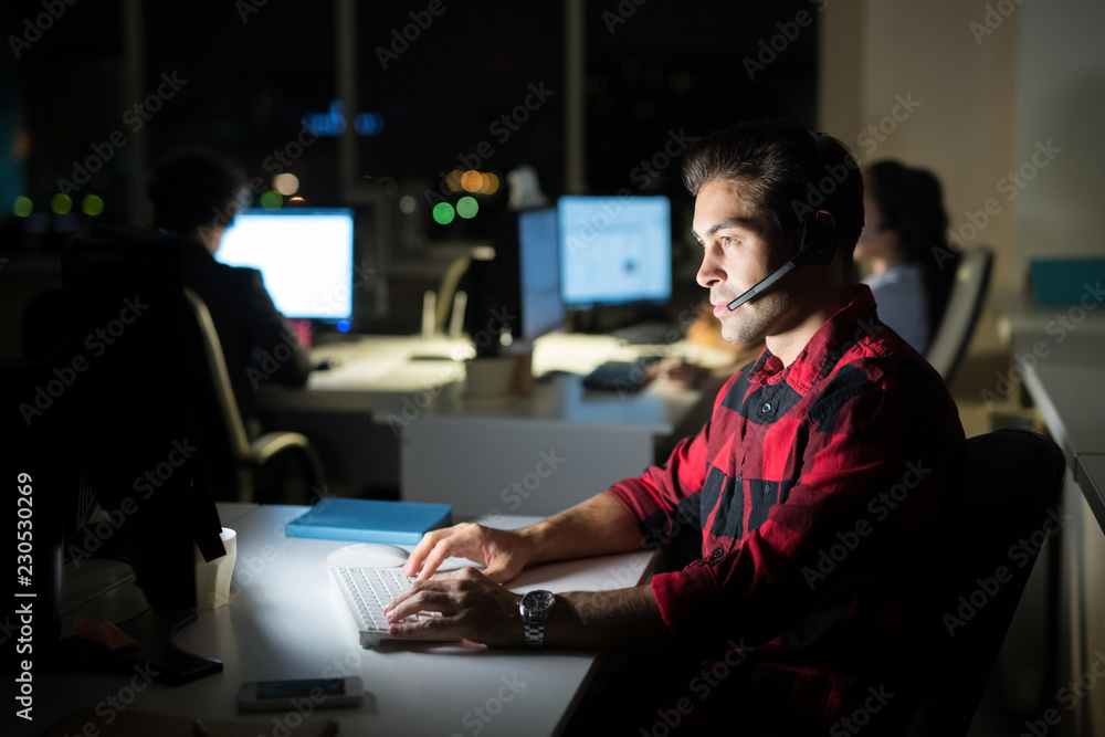 Side view portrait of male customer service operator working at night, copy space