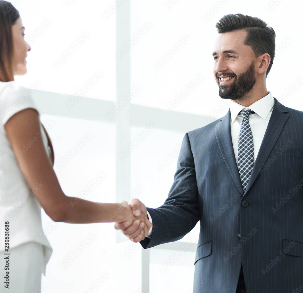 An attractive business man and woman team shaking hands An attractive business man and woman team shaking hands