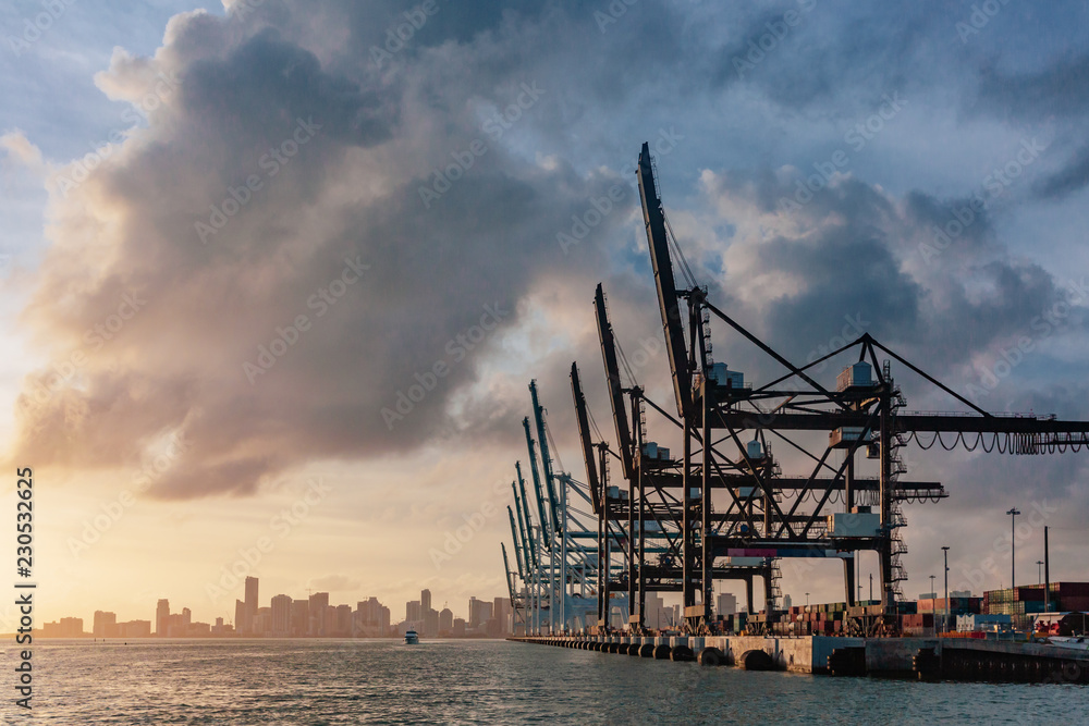 Cranes of the port of Miami and skyline of downtown Miami at sunset, in Florida, USA - obrazy, fototapety, plakaty 