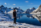 Woman tourist admiring the rugged mountains of Reine, Norway.  Lofoten Islands