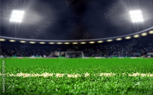 Empty soccer field stadium with green grass and bright spotlights at night