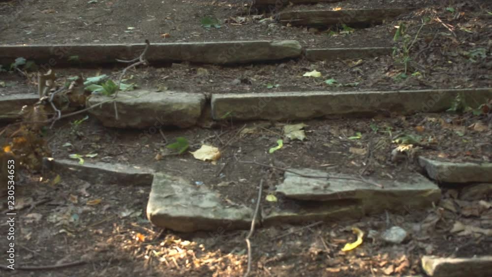 Man goes down the shattered stairs, legs close-up Man goes down the shattered stairs, legs close-up