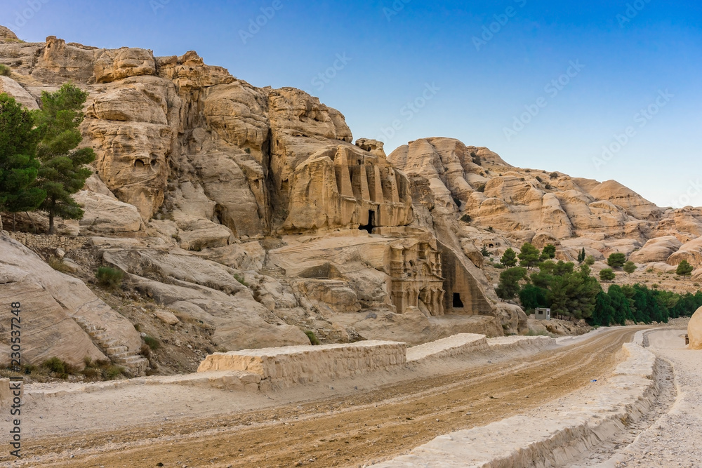 Fototapeta premium Yellow Obelisk Tomb Bab el-siq Triclinium Outer Siq Canyon Hiking To Entrance Into Petra Jordan Petra Jordan. In front of entrance to Petra
