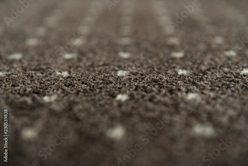 Brown carpet with a white dots texture. Indoor carpeting shoot in daylight.